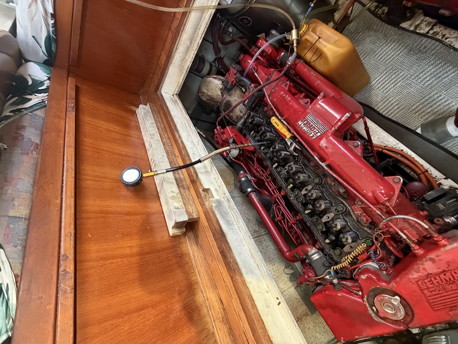 Ford Lehman marine diesel with the valve gear exposed and a compression tester connected