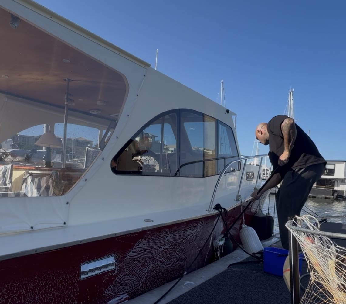 Washing down a vessel's hull alongside at the marina